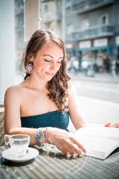 young beautiful woman reading book at the coffee