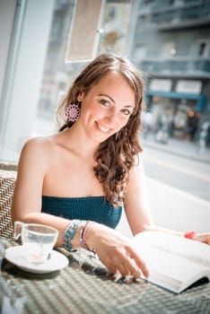 young beautiful woman reading book at the coffee