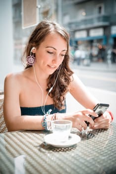 young beautiful woman listening to music at the coffee