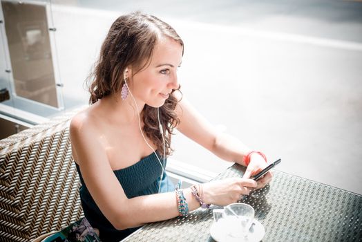 young beautiful woman listening to music at the coffee