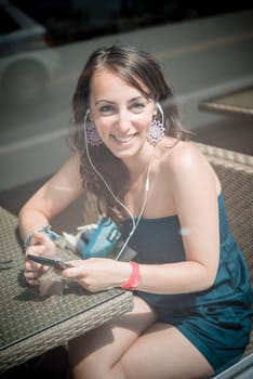 young beautiful woman listening to music at the coffee