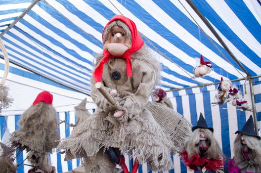 handmade diy ugly scary witch figure on broom sell in outdoor street market fair. halloween decoration.