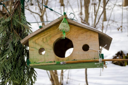 nailed wooden bird feeder with three holes fly