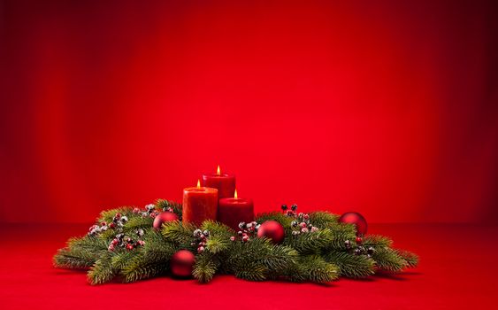 Red advent flower arangement with burning candles