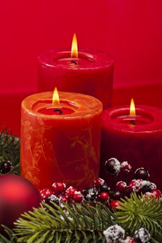 Red advent flower arangement with burning candles