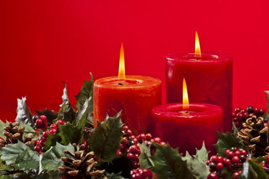 Red advent flower arangement with burning candles