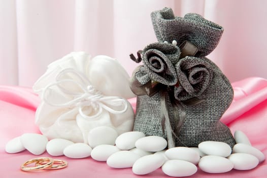  wedding rings and wedding favors on  elegant fabric background