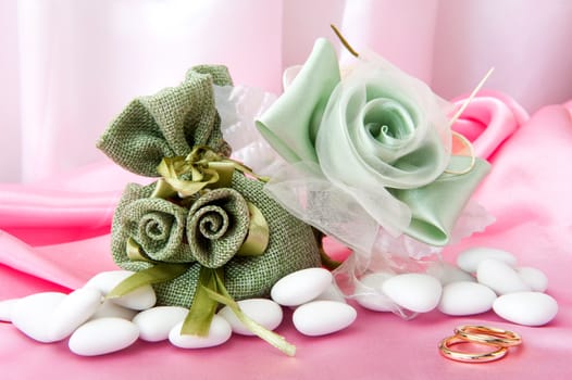  wedding rings and wedding favors on  elegant fabric background