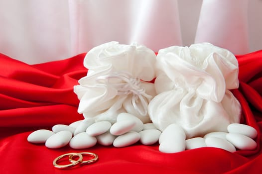  wedding rings and wedding favors on  elegant fabric background