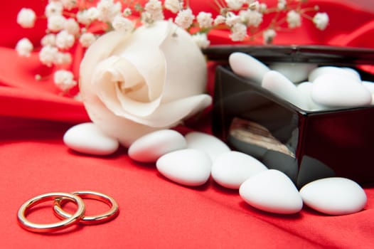  wedding rings and wedding favors on  elegant fabric background