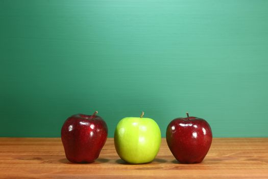 Three School Apples Sitting on Teacher Desk