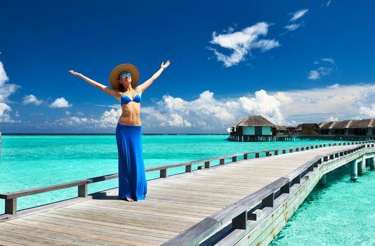 Woman on a tropical beach jetty at Maldives