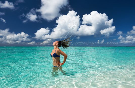 Woman splashing water with her hair in the ocean