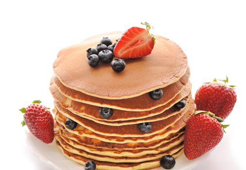 Delicious freshly prepared pancakes with strawberry and blueberries isolated on white