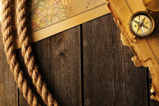 Antique brass compass and rope over old map
