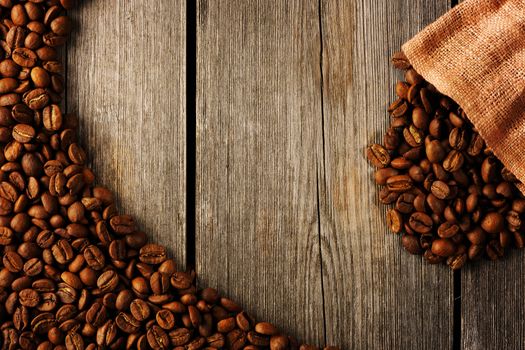 Coffee beans and bag over wooden background