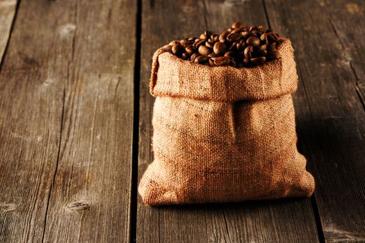 Coffee beans in bag on wooden table