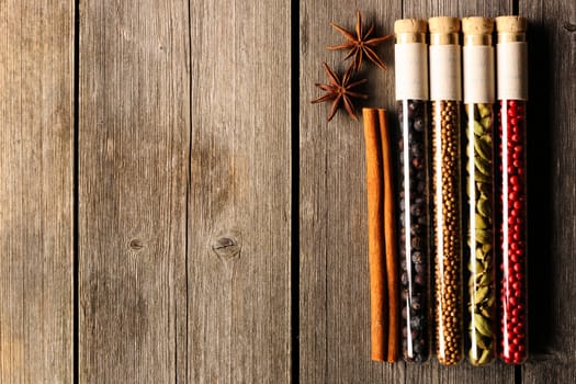 Spices in beakers on wooden background