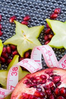 Fresh pomegranate and carambola fruits with tailor tape