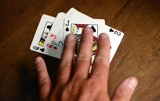 person winning at a slapjack card game with jack of spades on top of pile
