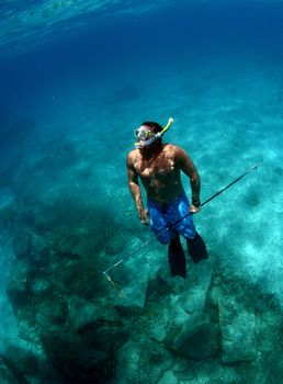 a man with spear gun underwater in ocean