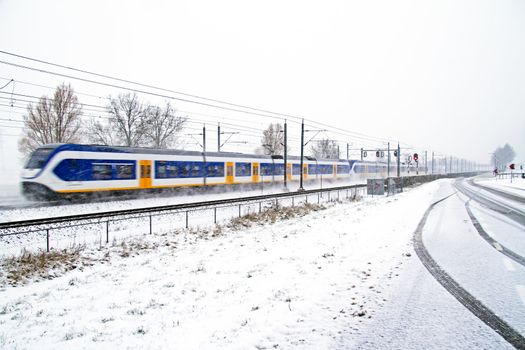 Train driving in a snowstorm in the Netherlands