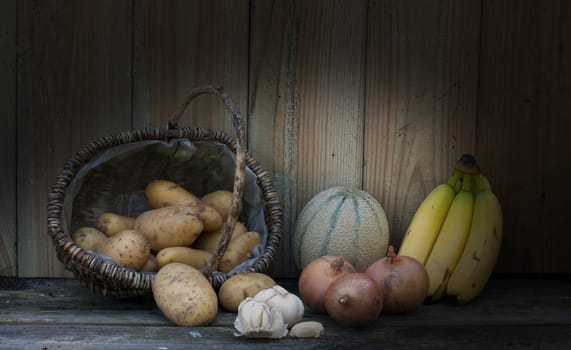 still life with bananas potato and onion