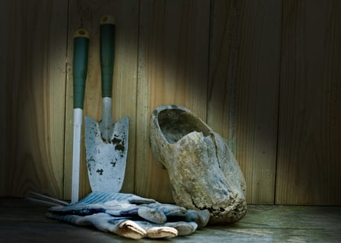 garden tools gloves and wooden shoe on a wooden shelf