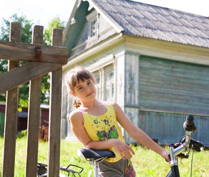 	  	
	  	
 Girl with a bicycle amid the rustic houses
