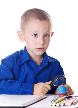 Schoolboy with a magnifying glass carefully consider Globe