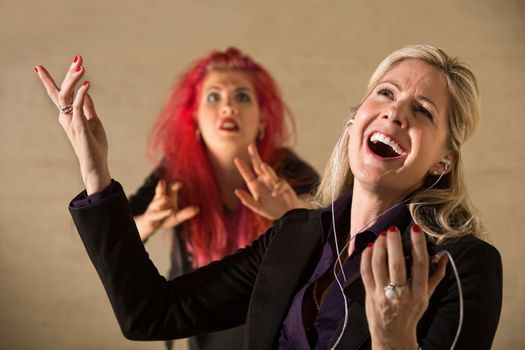 Embarrassed teen in pink hair with singing parent holding mp3 device