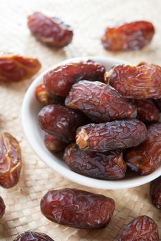 Dried date palm fruits or kurma, ramadan food which eaten in fasting month. Pile of fresh dried date fruits in a plate.