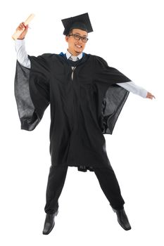 Full body excited Asian male university student in graduation gown jumping isolated on white background