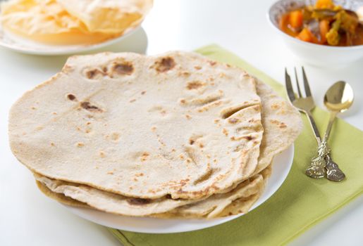 Chapatti roti or Flat bread, papadom and curry dhal. Indian food on dining table. 