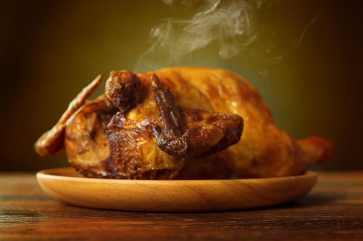 Whole roasted chicken, fresh from oven with heat steam.