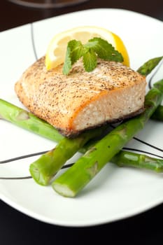 Freshly prepared salmon dish on a bed of asparagus spears.