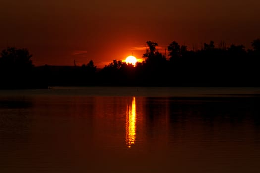 Colorful sunset over tranquil water surface.