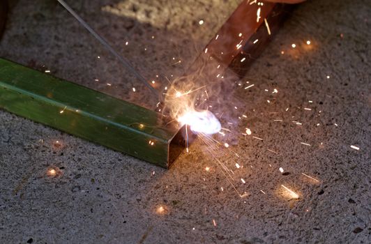 Iron welding with bright light and smoke at manufacturing