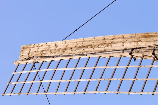 Old wooden windmill detail against the blue sky