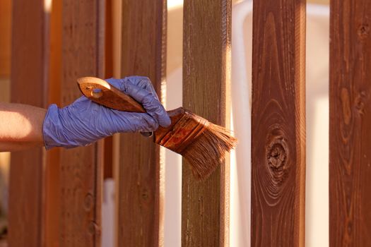 planks fence dyeing with brown paint and brush