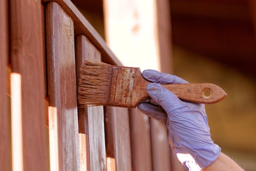 planks fence dyeing with brown paint and brush