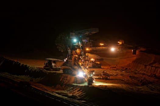 Coal mining in an open pit with huge industrial machine at night shoot