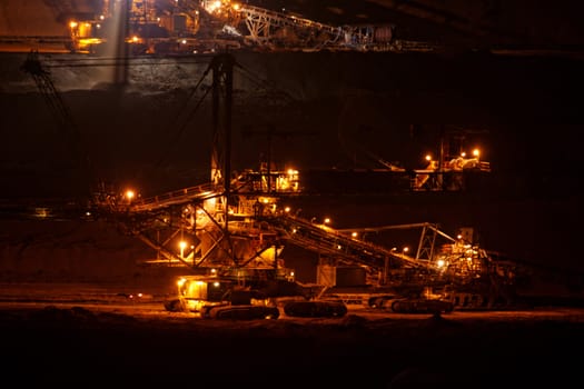 Coal mining in an open pit with huge industrial machine at night shoot