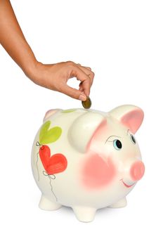 Piggy bank and hand with coin isolated on white background