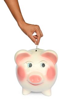 Piggy bank and hand with coin isolated on white background