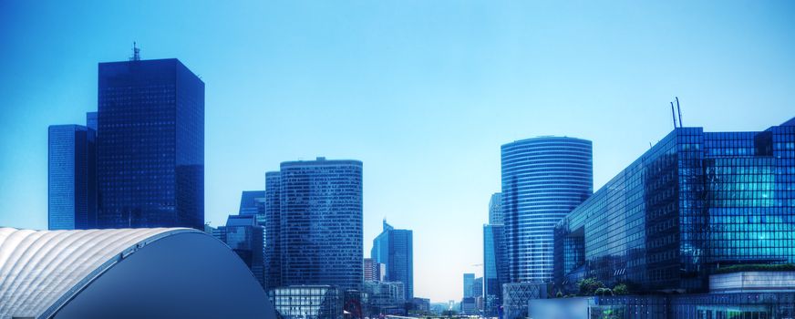 Business skyscrapers panorama in blue tint. La Defense financial district in Paris, France.
