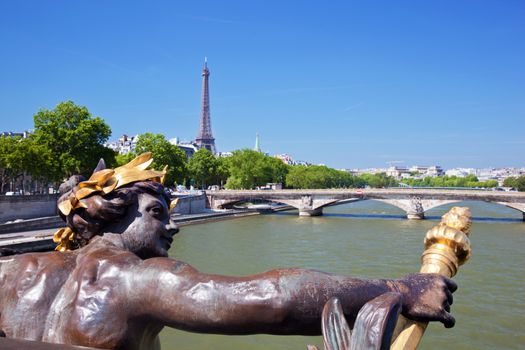 Eiffel Tower and bridge on Seine river in Paris, France. Artistic statue on Alexandre Bridge