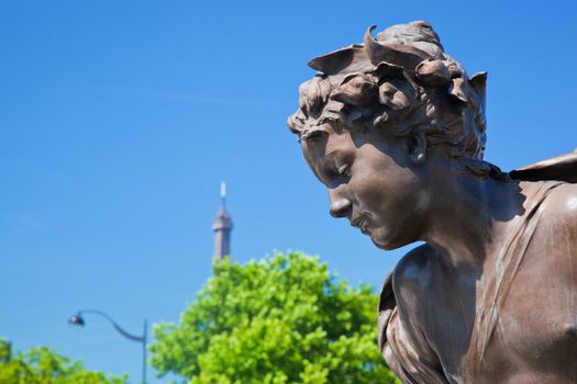 Artistic statue on Alexandre Bridge conceptually looking at Eiffel Tower, Paris, France.