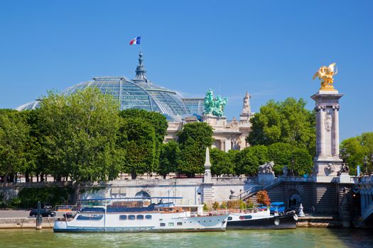 The Grand Palais and the Alexandre Bridge, Paris, France. Tourist ships on the Seine river