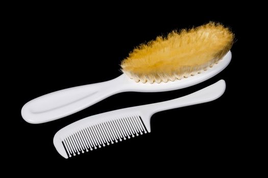 Two white hairbrushes on black background 